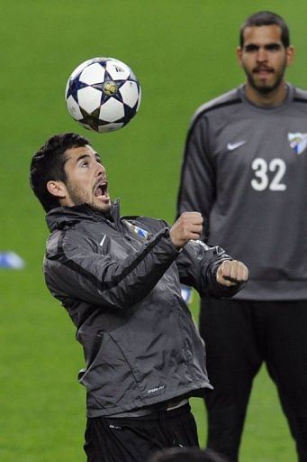 Malaga's Isco (L) controls a ball in front of teammate Pol Freixanet in Porto, on February 18, 2013